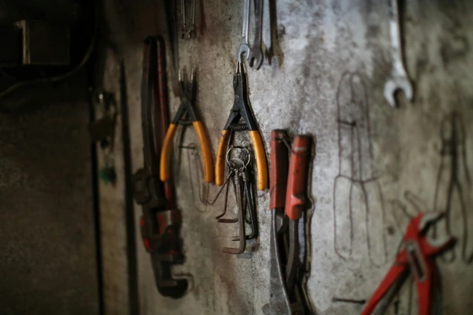 Assorted tools hanging on a workshop wall.